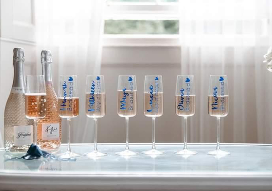 Personalised champagne flutes with blue writing and two bottles of wine